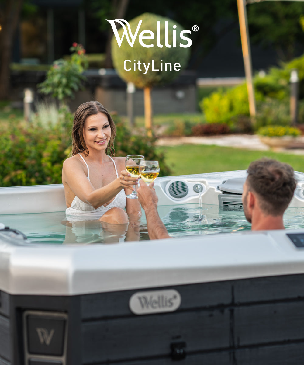 Happy couple celebrates with champagne in their spa bath in the backyard