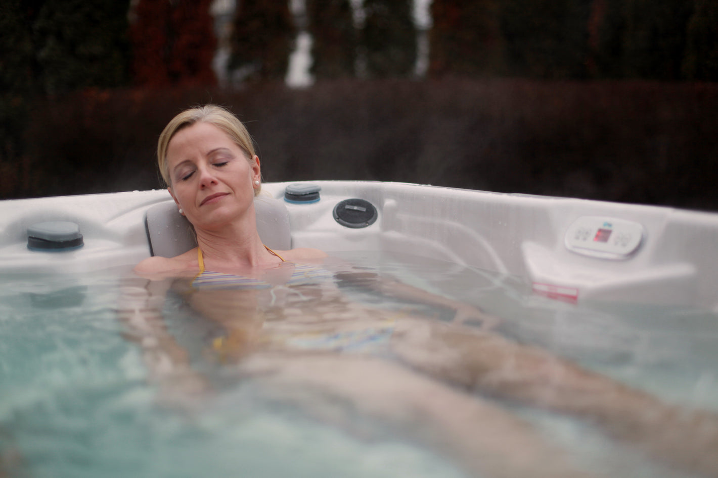 A woman in the affordable Wellis hot tub from is relaxing and enjoying hydromassage therapy